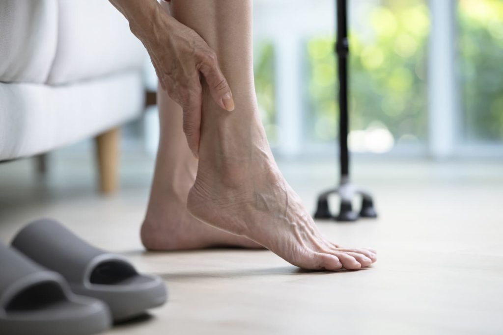 Elderly woman holding her ankle in pain after a slip and fall injury